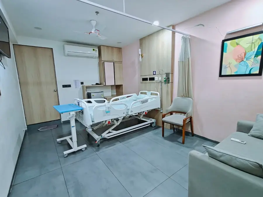 Electric patient bed and sofa in the super deluxe room at Pluto Hospital, Himatnagar